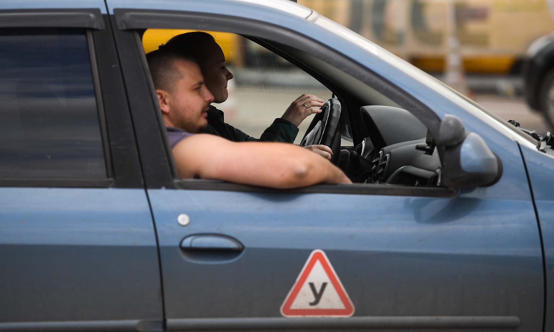 Инструктор и начинающий водитель во время занятий в автошколе