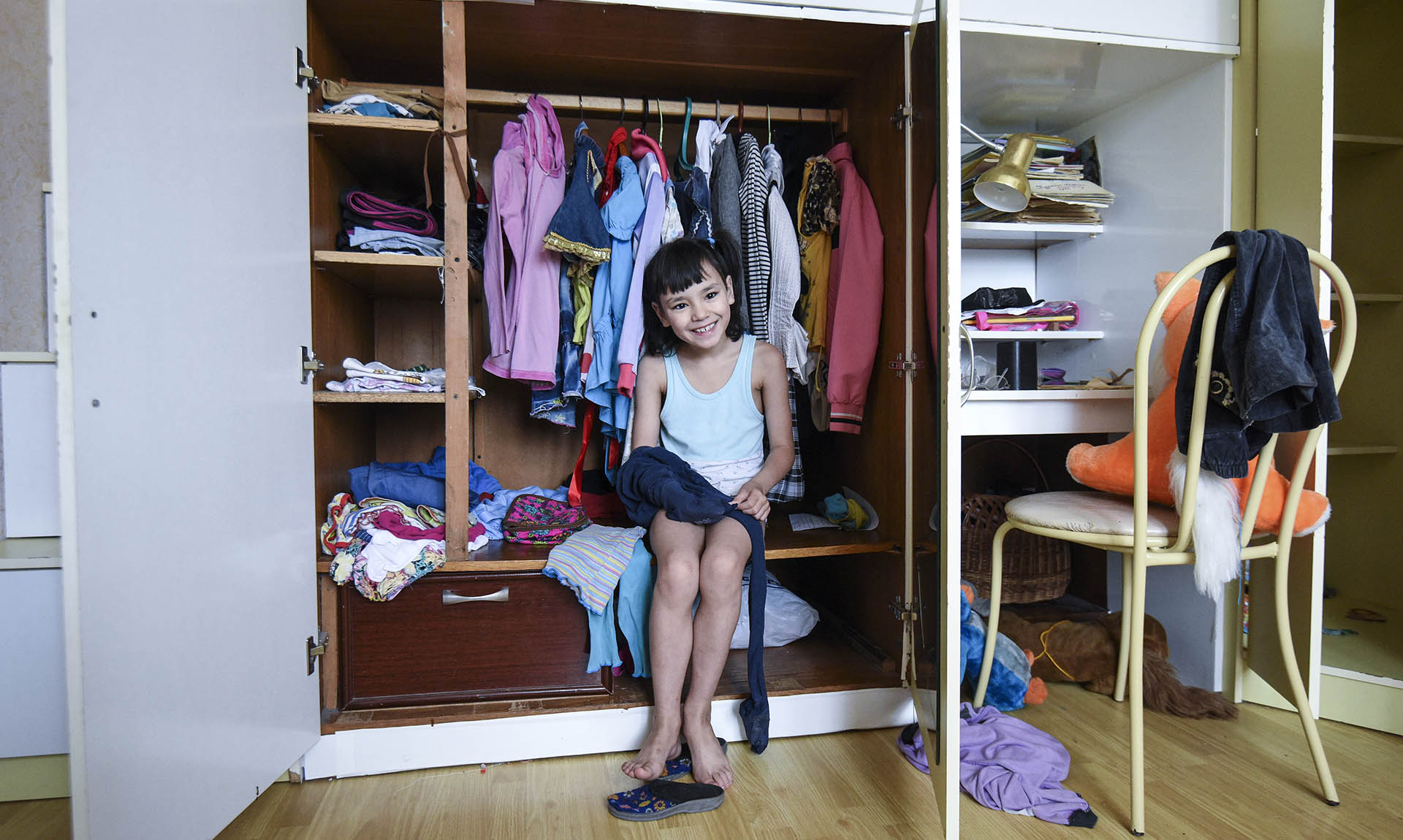 Девочка сидит в шкафу 