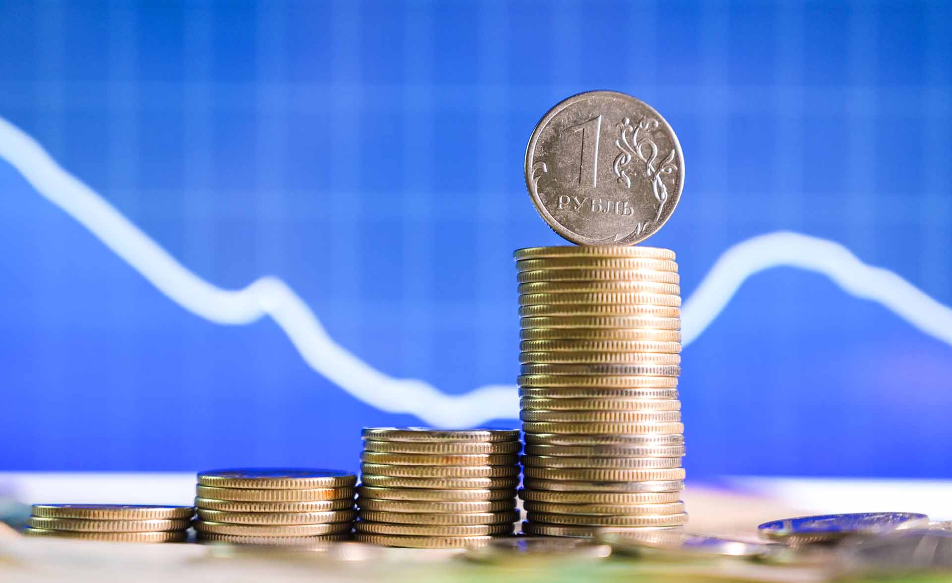рублевые монеты на фоне графика