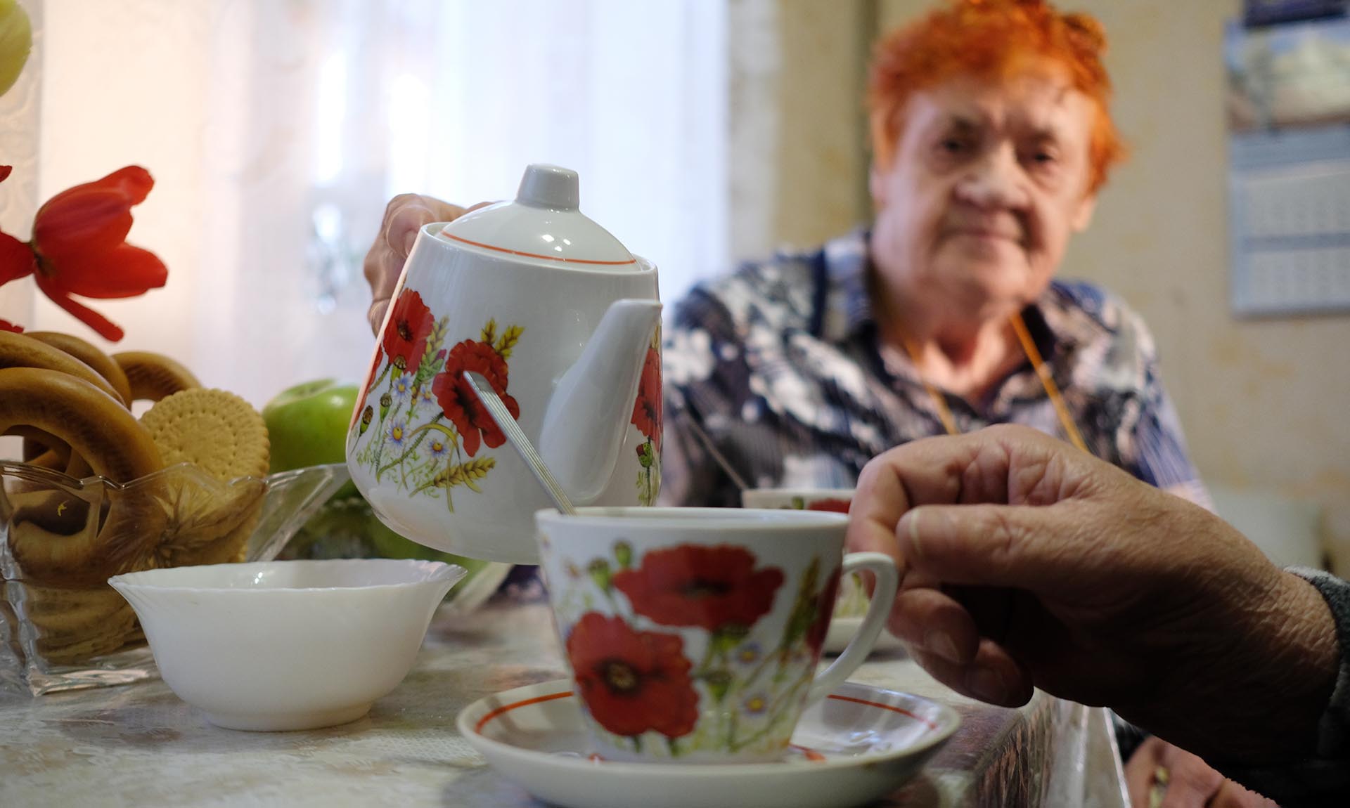 Пожилая семейная пара пьет чай дома