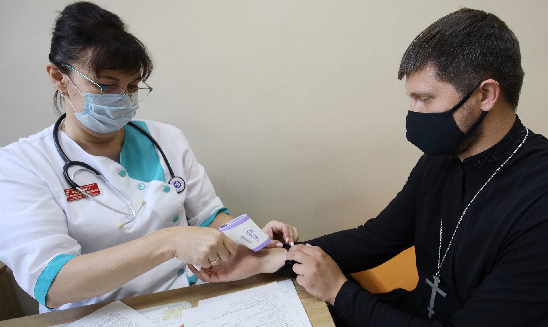 Врач измеряет температуру пациенту