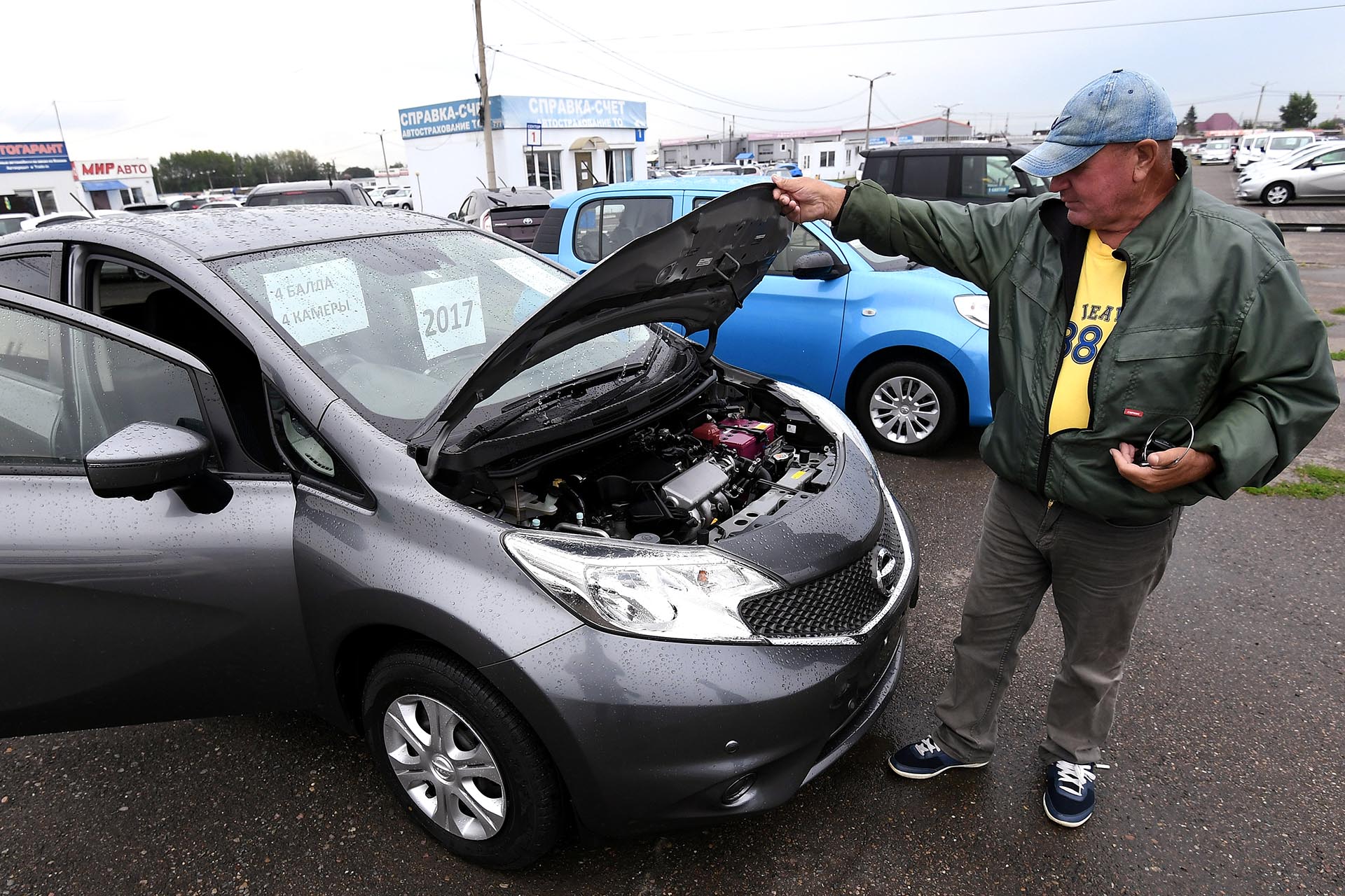 Продавец показывает автомобиль, выставленный на продажу 