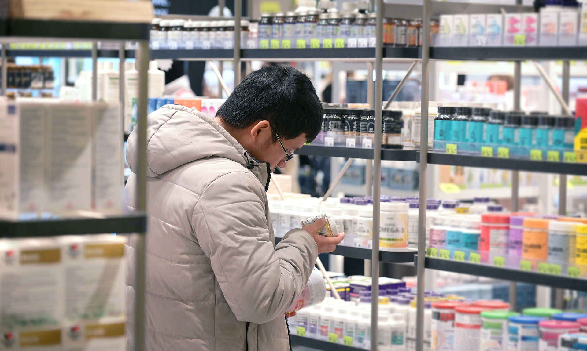 Мужчина в магазине выбирает витамины 