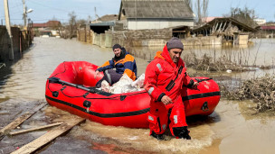 спасатели с надувной лодкой во время паводка