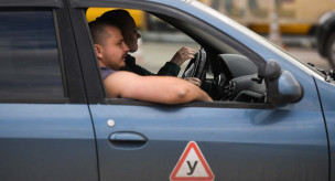 Инструктор и начинающий водитель во время занятий в автошколе