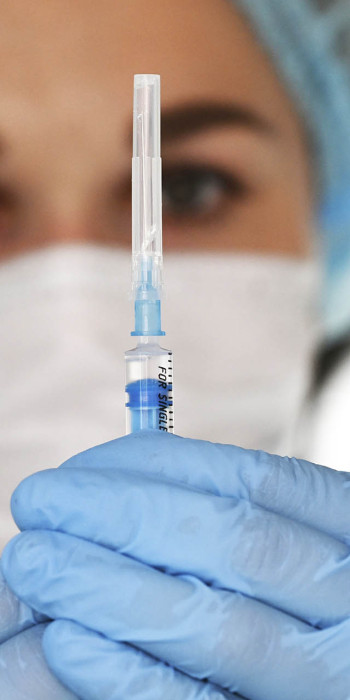 шприц с вакциной в руках у медработника