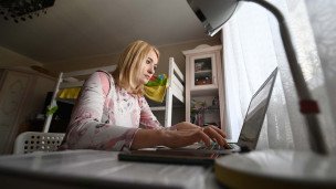 Женщина в квартире за ноутбуком