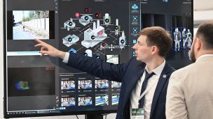 Cотрудник демонстрирует на экране работу над развитием городских систем