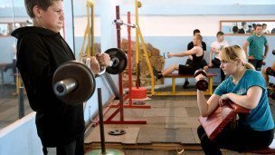 Молодые люди на занятиях физической культурой в спортивном клубе