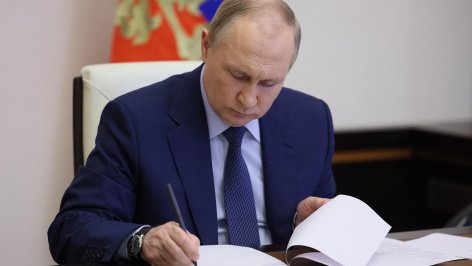 Владимир Путин подписывает документ