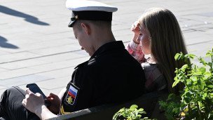 Молодая пара сидит на скамейке