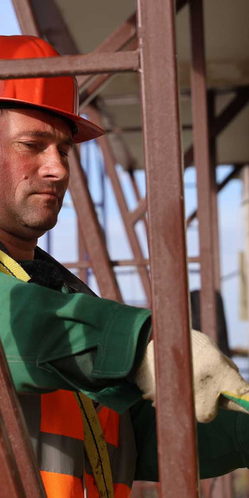 Строитель во время ремонта многоэтажного дома