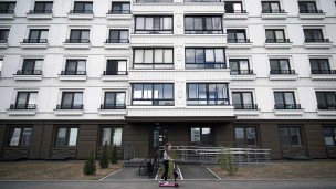 Ребенок на самокате около новостройки