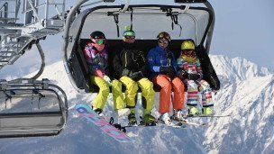 Отдыхающие на подъемнике на горнолыжном склоне