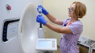 Сотрудница настраивает аппарат МРТ в онкологическом центре 