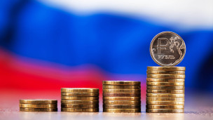 рублевые монеты на фоне флага России