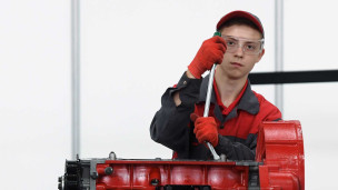 Молодой человек чинит двигатель