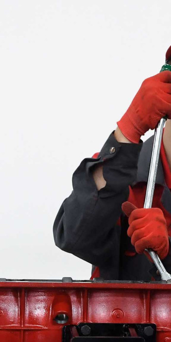 Молодой человек чинит двигатель