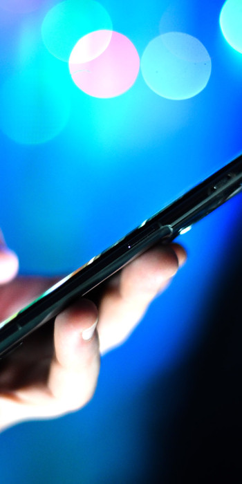 Мужчина держит в руках мобильный телефон