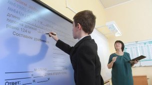 Ученик выполняет задание возле интерактивной доски