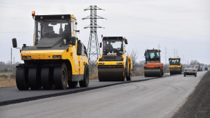 Сотрудники дорожно-строительной компании ремонтируют участок дороги