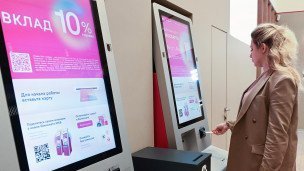 Клиент вставляет карту в банкомат в отделении банка