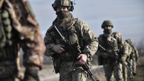 Мобилизованные в полном обмундировании идут друг за другом