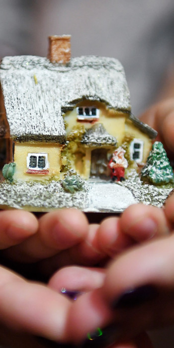 Женщина с ребенком держат макет дома