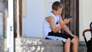 Ребенок с телефоном на улице летом