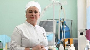 Медработница напротив медицинской аппаратуры