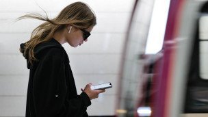 Девушка на платформе с телефоном 