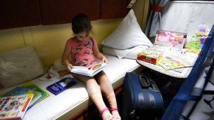 Ребенок с игрушками в детском купе