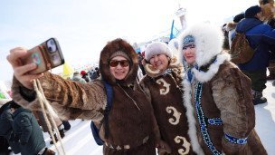 Женщины фотографируются на телефон