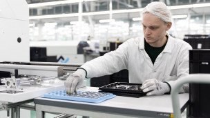 Сотрудник в цехе монтажа печатных плат производственного комплекса 