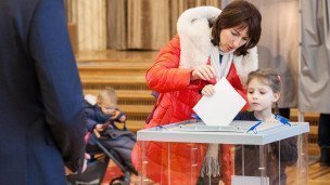 Женщина с ребенком на голосовании