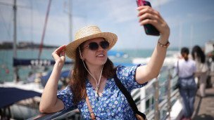 Туристка делает селфи на берегу моря