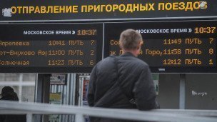 Пассажир на фоне расписания пригородных поездов 