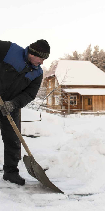 мужчина чистит снег лопатой