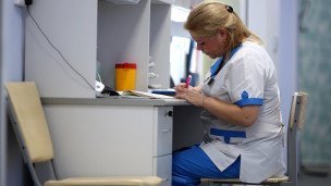 Постовая медицинская сестра за столом