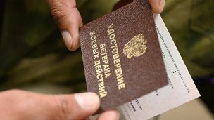 Участник СВО держит удостоверение ветерана боевых действий