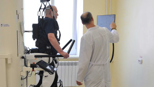 Пациент занимается на роботизированном комплексе для улучшения функций нижних конечностей 