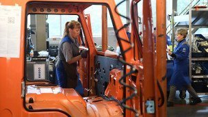 Сотрудница автомобильного завода во время сборки