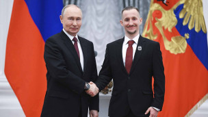 Президент РФ Владимир Путин и сотрудник научно-исследовательского института на церемонии вручения премий