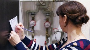 Женщина переписывает показания счетчика учета воды