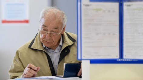 Посетитель заполняет документы зале Федеральной налоговой службы 
