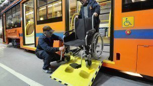 работники  вагоностроительного завода тестируют перемещение инвалидной коляски на трапе в трамвае