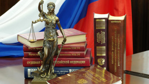 Статуя Фемиды и юридическая литература на столе