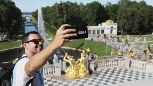 Иностранный турист делает селфи в Петергофе