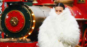 Девушка в шубе возле рождественского поезда