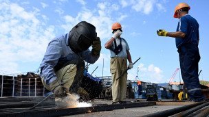 Рабочие на строительстве моста через реку